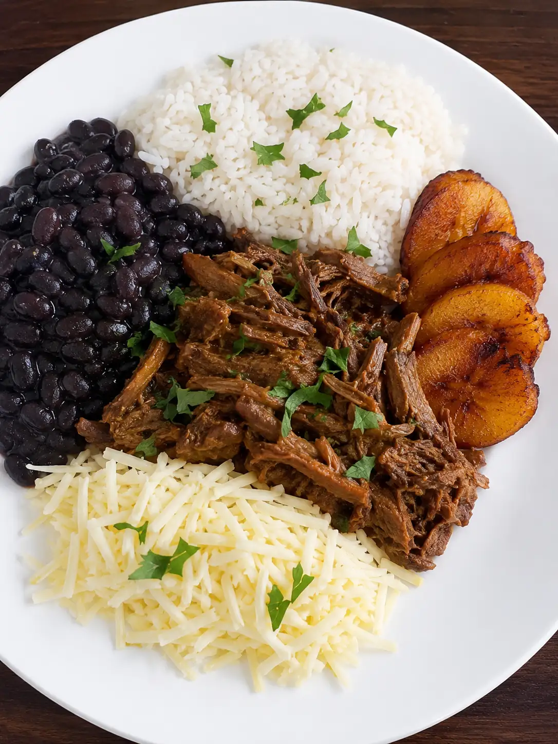 Plate of pabellón criollo with shredded beef, black beans, white rice and fried plantain